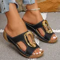 Detail of women's black wedge sandals featuring a large gold metal buckle and open toe - 36 / Black