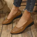 Close-up of stylish brown crocodile pattern wedge heel dress shoes for women. - Brown