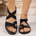 Detail shot of women's black summer flat sandals featuring elastic cross straps on feet - 36 / Roman Style (528#) / Black