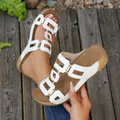 Detail van witte plateausandalen met elegante gouden gespen en een open teenontwerp - Wit