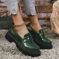 Κοντινό πλάνο από κομψά πράσινα λουστρίνι loafers με πλατφόρμα σε ένα χαλίκι μονοπάτι. - Πράσινο
