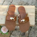 Close-up of brown mesh flat slippers with decorative gold buckle on wooden background - 35 / Brown
