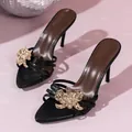 Vue détaillée de sandales à talons aiguilles noires avec fleur métallique dorée chic - 35 / Noir