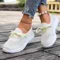 Detailed view of white breathable mesh slip-on sneakers for women worn on wooden path - Milky White