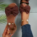 Elegant brown flat sandals for women with large bow and pearl ankle strap detail - Brown