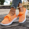 Close-up of breathable orange mesh slip-on walking sneakers for women on wooden deck - 36 / Orange Red