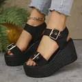 Close-up of women's black espadrille wedge sandals with gold buckles and straw sole - Black