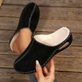 Macro view of black suede mules featuring thick faux fur lining and white stitching. - 36 / Black