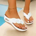 Close-up of white wedge flip-flops with floral decoration on a poolside background - 36 / White