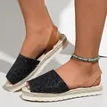 Detailed view of women's black sequin peep-toe flat sandals with tan heel straps - Black