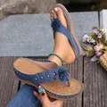 Gedetailleerd beeld van blauwe teenslippers met sleehak, decoratieve bloem en studs - Blauw
