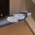 Détail en gros plan d'une bague géométrique ouverte sertie de zircons brillants - Style Aile Zirconia (2#) / Ouvert Réglable / Argent