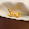 Close-up detail of matte gold finish heart hoop earrings with a clear zircon stone - Hoop Earrings-Gold
