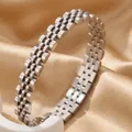 Detail van een geborsteld roestvrijstalen horlogeband-stijl armband op luxe gouden zijden stof. - Vijf Kralen Armband / 8mm Breed / Staalkleur