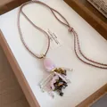Detail van bohemien ketting met roze stenen hanger en kwastjes van tijgeroog kralen. - Bruin en Roze