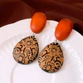 Gros plan de boucles d'oreilles en bois en forme de goutte avec motif floral noir - Tige en Argent - Café - Noir