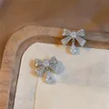 Gedetailleerd overzicht van strik oorknoppen met zirkonia hangers in zilveren afwerking - Strik Oorknopjes (HE35543) / Zilveren Naald - Zilver (Echt Verguld)