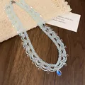 Collier en perles bleu clair avec bordure en dentelle et breloques en cristal. - Collier-Bleu Ciel