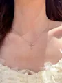 Détail d'un collier en argent avec pendentif croix en zircons porté par un modèle - Argent