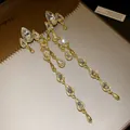 Detail of elegant long gold drop tassel earrings with sparkling clear waterdrop crystals - Gold