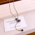 Close-up of elegant necklace with purple stone beads and a silver-tone star cage pendant. - Silver-Purple