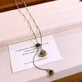 Close-up of tiger eye stone necklace with a geometric star cage pendant detail. - Silver-Coffee