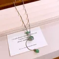 Macro detail of hexagonal star cage pendant with green stone beads on silver necklace - Silver-Green