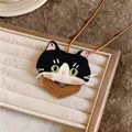 Close-up of a cute embroidered black and white cat pendant on a jewelry tray - Black and White Patchwork Kitten Pendant / Coffee Cord with Black Cat