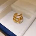 Nahaufnahme goldene mehrlagige Ohrmanschette mit quadratischem Zirkon in Schmuckschatulle - Mehrlagiger Quadratischer Zirkonia-Stil (HE35738) / Einzelstück / Gold