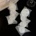 Nahaufnahme der weißen Chiffon- und Perlenohrringe im eleganten Strandstil - Ohrclips / Weiß
