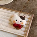 Detailed macro shot of the knitted cat pendant necklace with red bow decoration - Kitten Pendant with Red Bow / Coffee Cord with White Cat