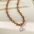 Gedetailleerde opname van luxe bruine tijgeroog parelketting met vierkante zirkoon hanger - Ketting-Koffie