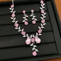 Nahaufnahme von Halskette und Ohrringen mit eleganten rosa Kristallblumen und Blattdesign - Ohrstecker & Halskette Set / Silber-Rosa