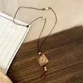 Detailed view of the handcrafted ethnic wooden pendant and beaded cord of the long necklace - Square Pendant / Coffee