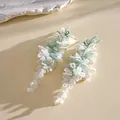 Gros plan élégant montrant la texture délicate des boucles d'oreilles à pompons perlés. - 44# Style Tige en Argent / Blanc-Bleu