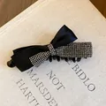 Détail d'une élégante pince à cheveux nœud en satin noir ornée de strass brillants - S / Noir