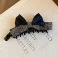 Gros plan d'une pince à cheveux noire à nœud ornée de strass élégants - L / Noir