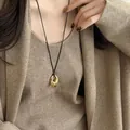 Minimalistische Halskette mit goldenem ovalem Anhänger und schwarzer Kordel für Damen - Glänzender Stil / Gold