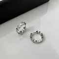 Detail view of silver-plated hoop earrings with hexagonal pattern and embedded zircons. - Clasp Back / Silver