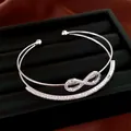 Detailansicht eines silberfarbenen Infinity-Armreifs mit funkelnden Zirkoniasteinen - Silber