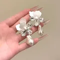 Vista dettagliata degli orecchini a fiore bianco con strass e perle barocche eleganti - French Flower Pearl Style / Argento-Bianco