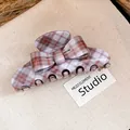 Macro view of a retro plaid bow hair claw clip with stylish grey and orange check pattern - Plaid Bow Claw Clip / Brown