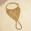 Detailansicht eines goldenen Spinnennetz-Armbands mit Perlen-Mesh-Design. - Gold Quaste