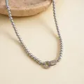 Detailopname van een zilvergrijze parelketting met een geometrische sluiting met zirkonia - Grijs