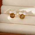 Detailweergave van 14k vergulde strik oorknopjes met fonkelende zirkonia steentjes - Vierkante Strik / Goudbruin