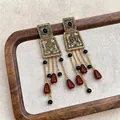 Vintage palace style square tassel earrings with red-brown beads on a wooden tray - Gold with Black and Coffee Beads