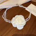 Detailansicht eines vintage cremefarbenen Stoffrosen- und dreireihigen Perlenchokers. - Weiß-Hellgelb