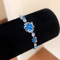 Silver bracelet with blue clover zircon flowers on black display stand - Hollow Flower / Silver-Blue