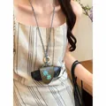 Detailed view of a model wearing a green leather glasses holder necklace with sun embroidery - Black White and Dark Green Necklace