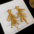 Close-up detail of vintage matte gold fish and starfish earrings with white pearls - Vintage Ocean Style Earrings (HE35780) / Gold-White